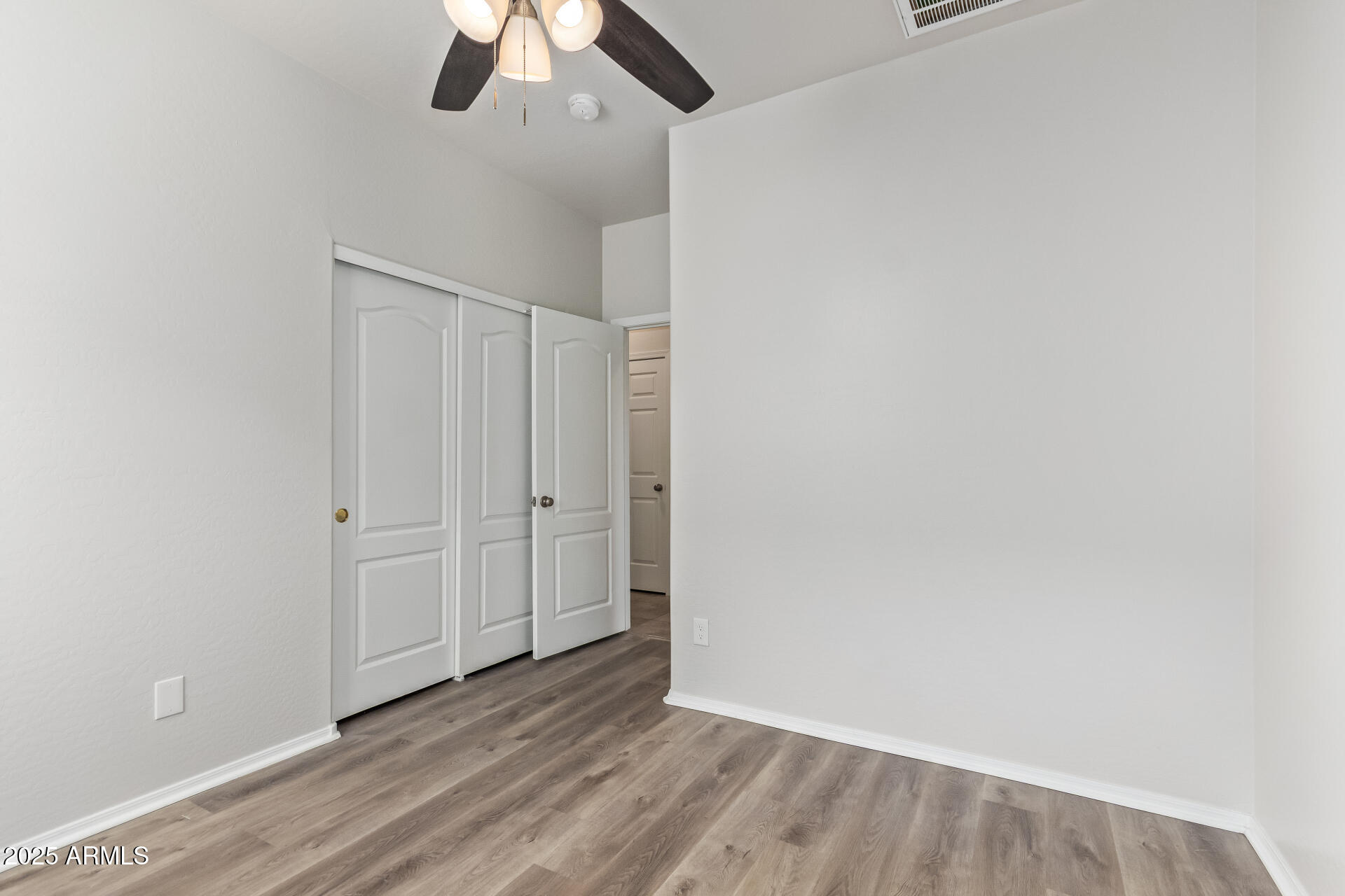 21382 East Via Del Rancho Queen Creek, AZ 85142 - Photo 18 of 29 an empty room with a ceiling fan and wooden floor