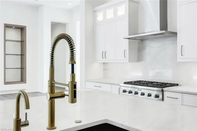 a white kitchen with stainless steel appliances and a counter space