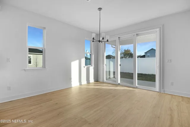 a view of a room with wooden floor and a ceiling fan