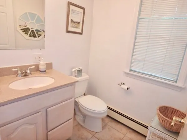 a bathroom with a granite countertop sink mirror vanity and toilet