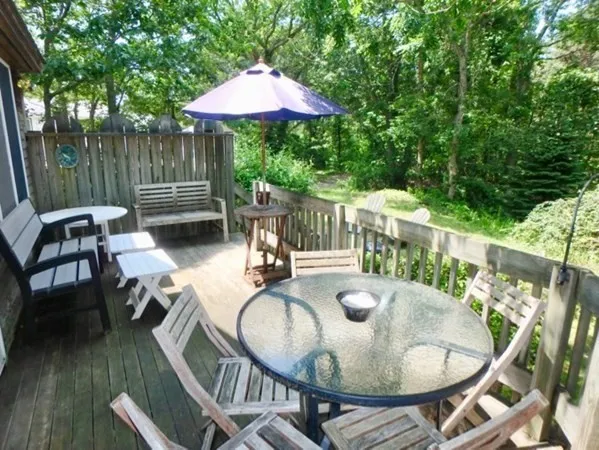 a patio with wooden table and chairs
