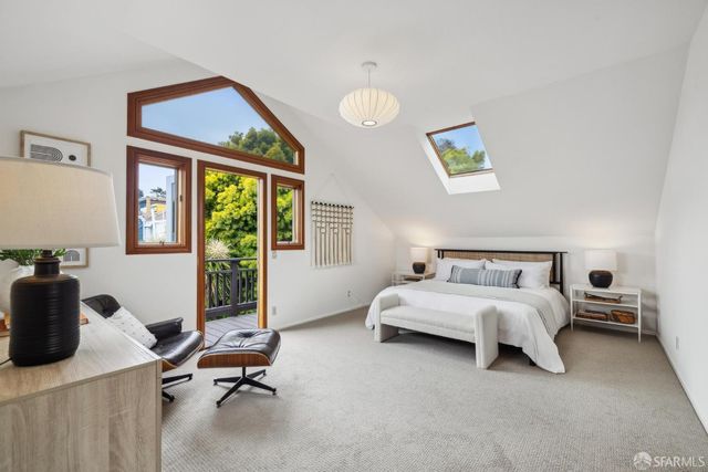 a bedroom with a large bed and two windows