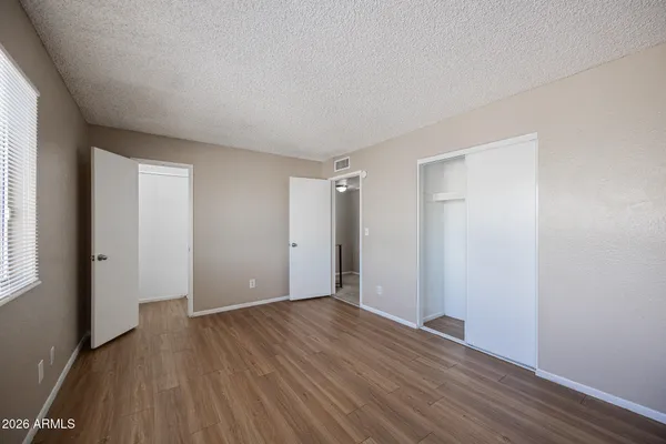 an empty room with wooden floor and windows