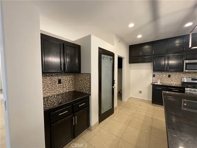 a kitchen with stainless steel appliances granite countertop a refrigerator and a stove top oven