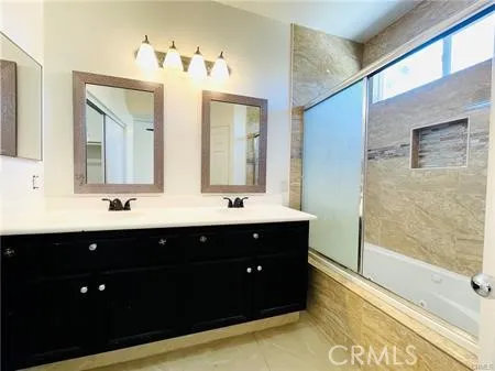 a bathroom with a double vanity sink mirror and bathtub