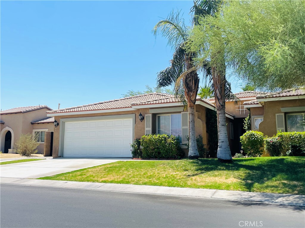83107 Greenbrier Drive Indio, CA 92203 - Photo 2 of 29 a front view of a house with a yard and potted plants