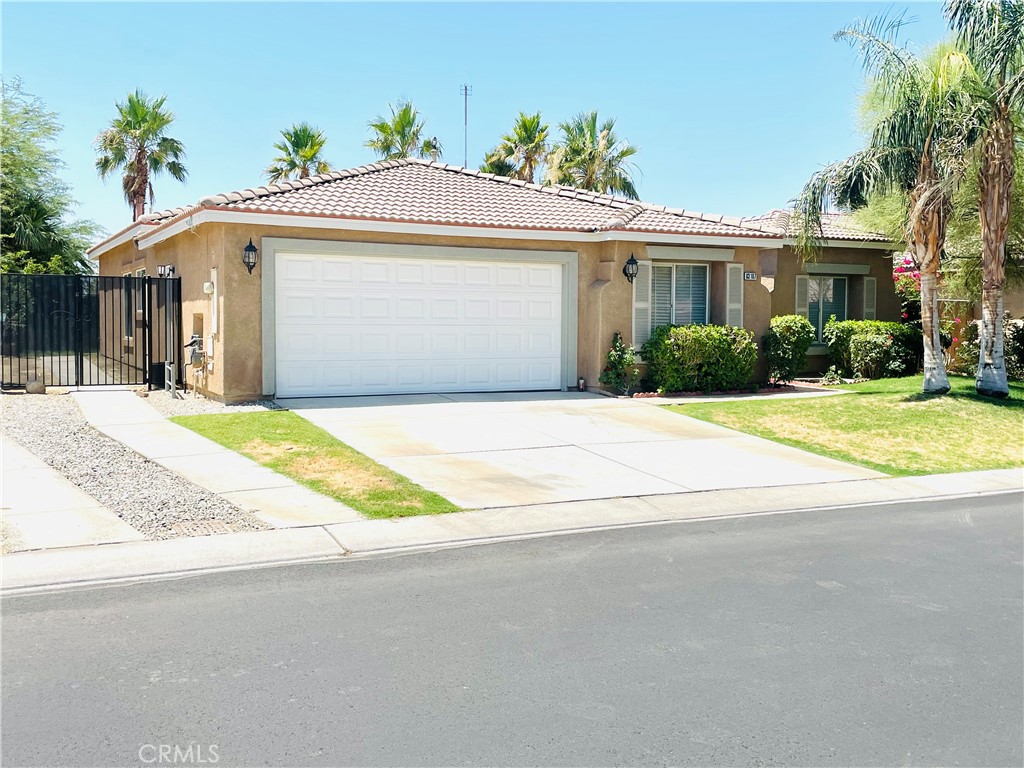 83107 Greenbrier Drive Indio, CA 92203 - Photo 3 of 29 a front view of a house with a yard and potted plants
