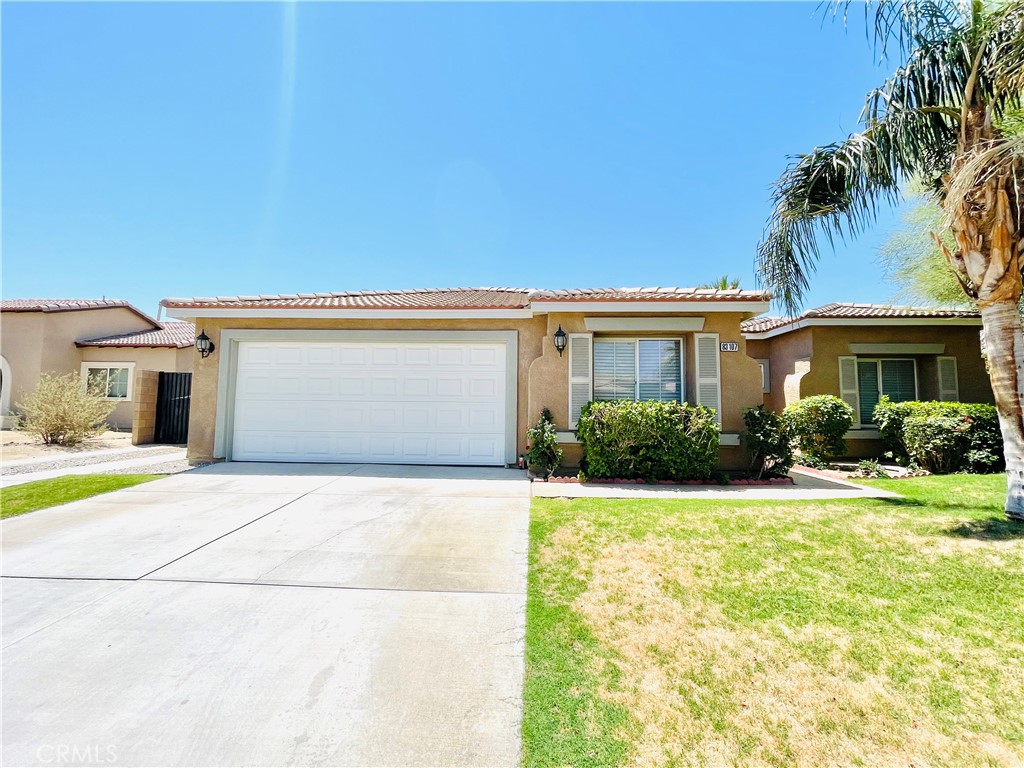 83107 Greenbrier Drive Indio, CA 92203 - Photo 4 of 29 a front view of a house with a yard and garage
