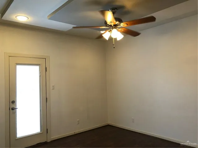 an empty room with a window and a fan