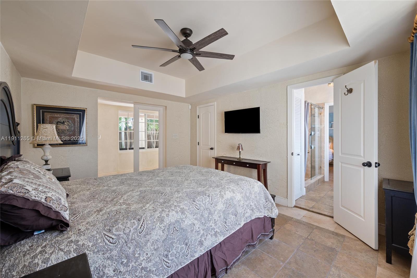 3308 Northeast 16th Place Fort Lauderdale, FL 33305 - Photo 24 of 31 a bedroom with a large bed a flat tv screen and a dresser