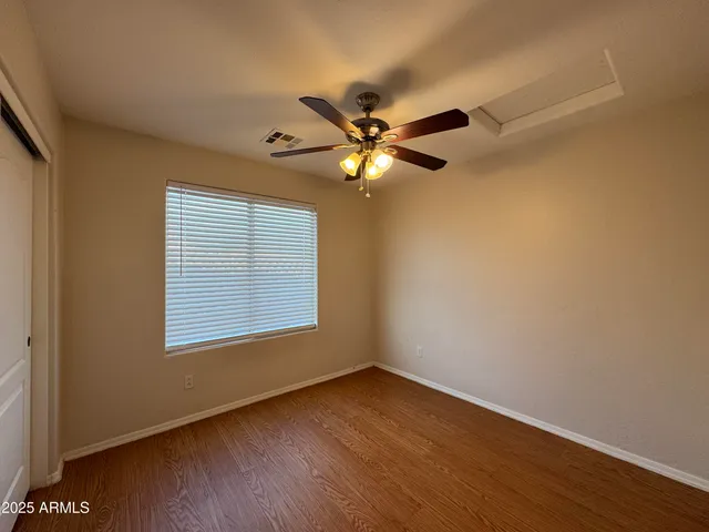 a view of an empty room with a window and a fan