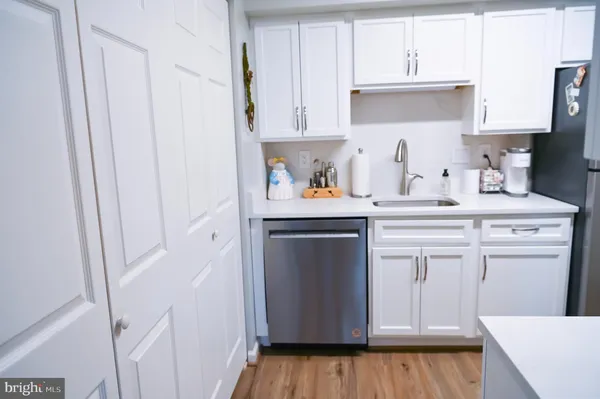 a kitchen with stainless steel appliances a sink a stove a refrigerator and cabinets
