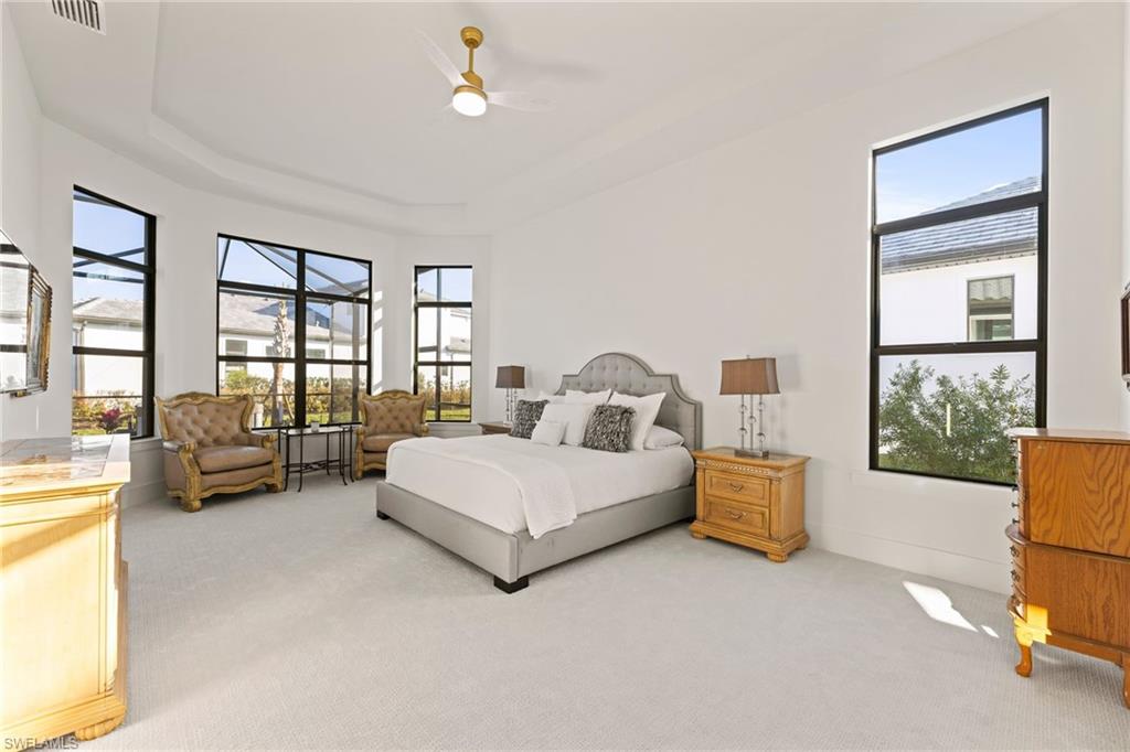 16140 Verilyn Circle Naples, FL 34110 - Photo 11 of 44 a spacious bedroom with a bed couch and a large window