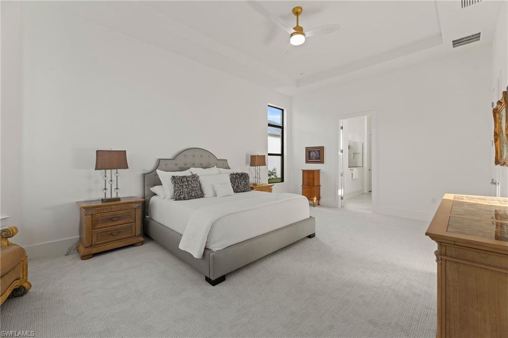 16140 Verilyn Circle Naples, FL 34110 - Photo 12 of 44 a spacious bedroom with a bed and a lamp