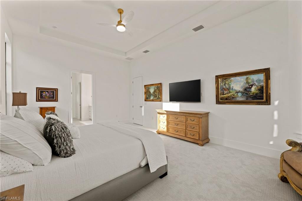 16140 Verilyn Circle Naples, FL 34110 - Photo 14 of 44 a bedroom with a bed and a flat screen tv