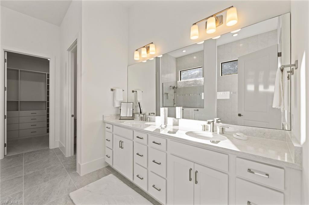 16140 Verilyn Circle Naples, FL 34110 - Photo 15 of 44 a bathroom with double sink and a mirror