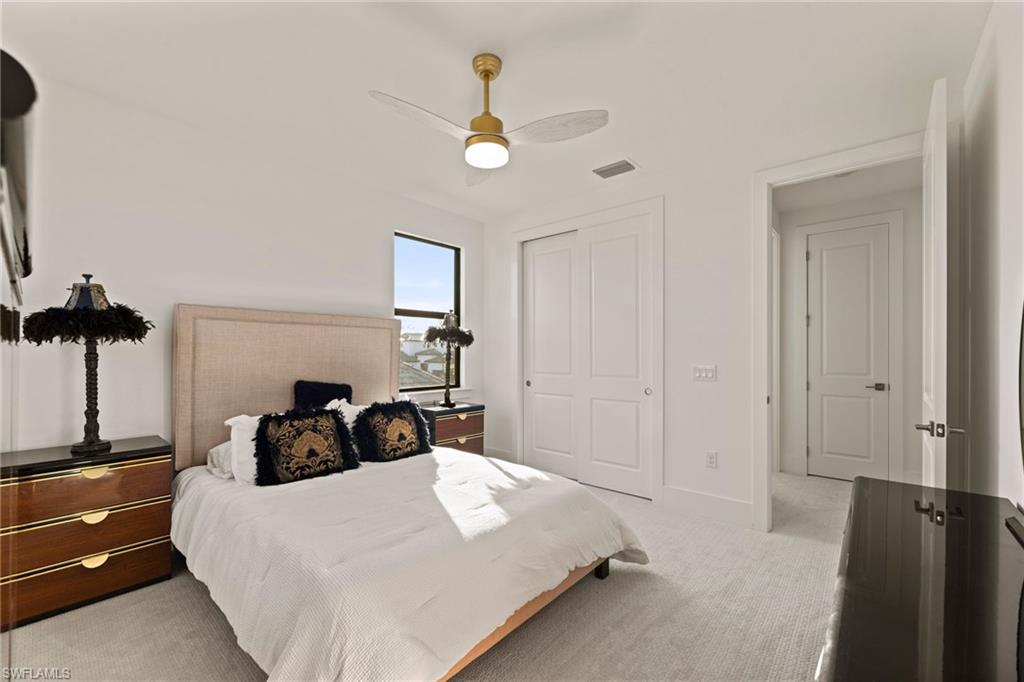 16140 Verilyn Circle Naples, FL 34110 - Photo 32 of 44 a bedroom with a bed and a chandelier