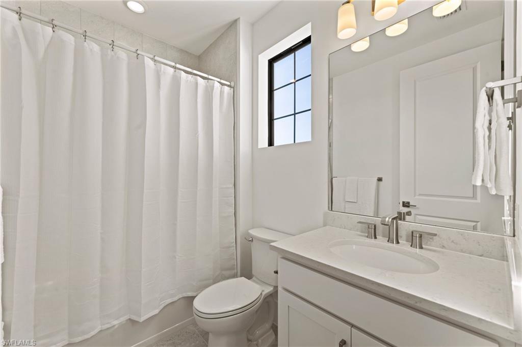 16140 Verilyn Circle Naples, FL 34110 - Photo 33 of 44 a bathroom with a granite countertop sink toilet and a mirror