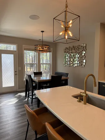 a kitchen with a dining table chairs and chandelier
