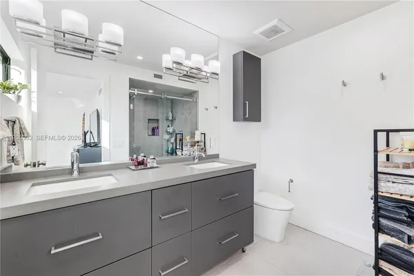 a bathroom with a sink a toilet and a mirror