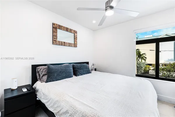 a bedroom with a bed and a large window