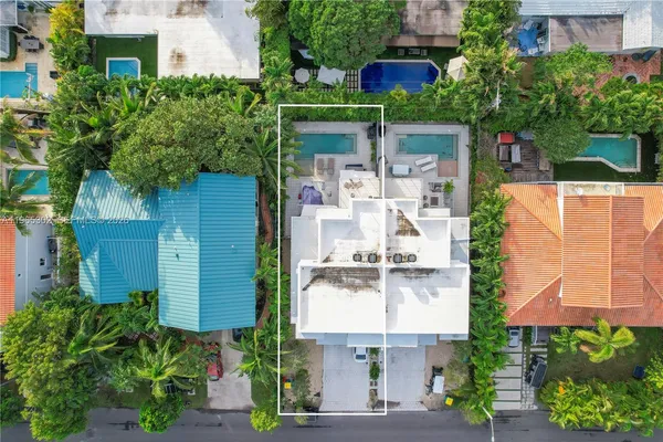 an aerial view of residential houses with outdoor space and street view