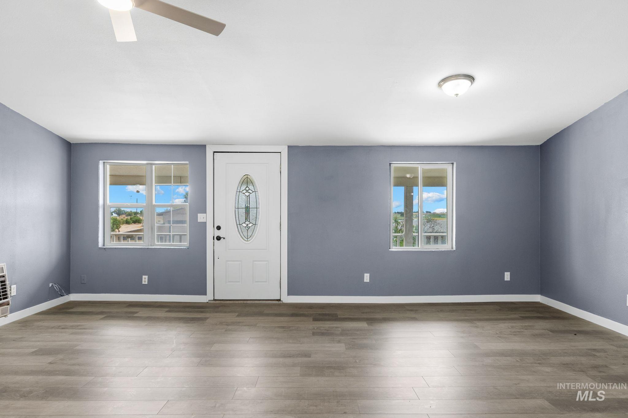 18338 Pride Lane Caldwell, ID 83607 - Photo 35 of 50 Entry room featuring wood-finish flooring, light blue walls, and a white front door with decorative glass