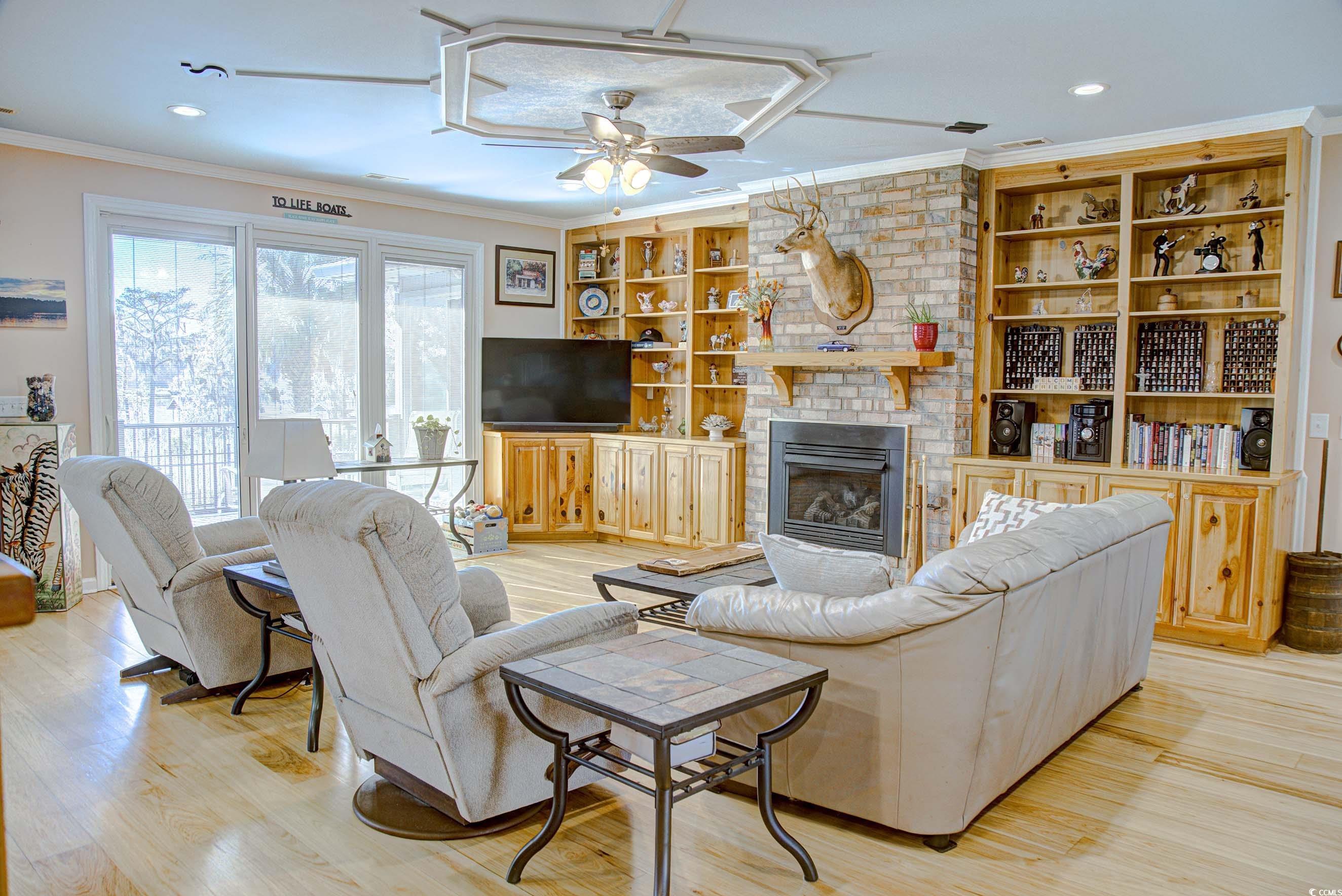 3637 Choppee Road Georgetown, SC 29440 - Photo 13 of 40 Living room with ornamental molding, a brick fireplace, recessed lighting, light wood-style floors, and built in shelves
