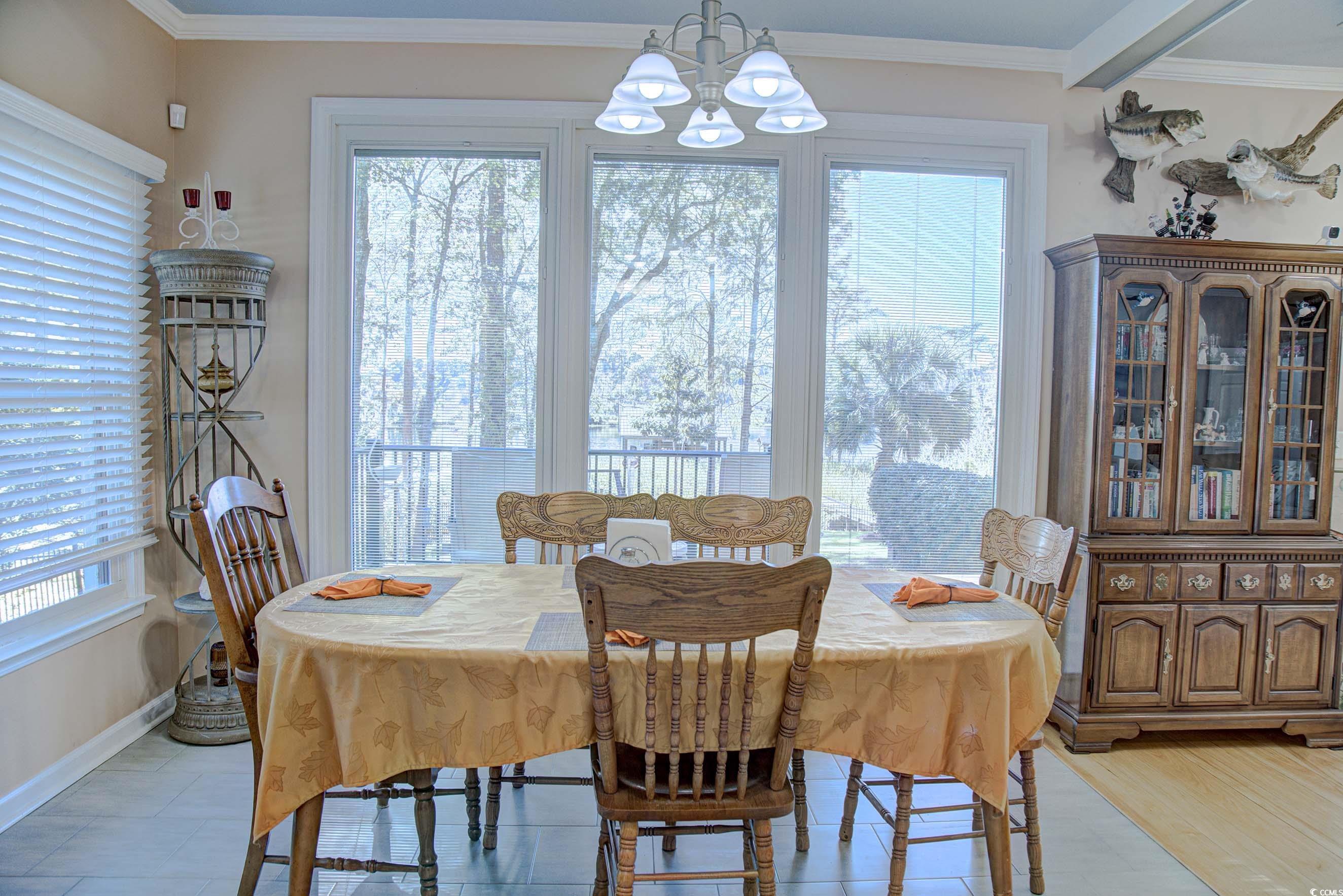3637 Choppee Road Georgetown, SC 29440 - Photo 17 of 40 Dining space with ornamental molding, healthy amount of natural light, and a chandelier