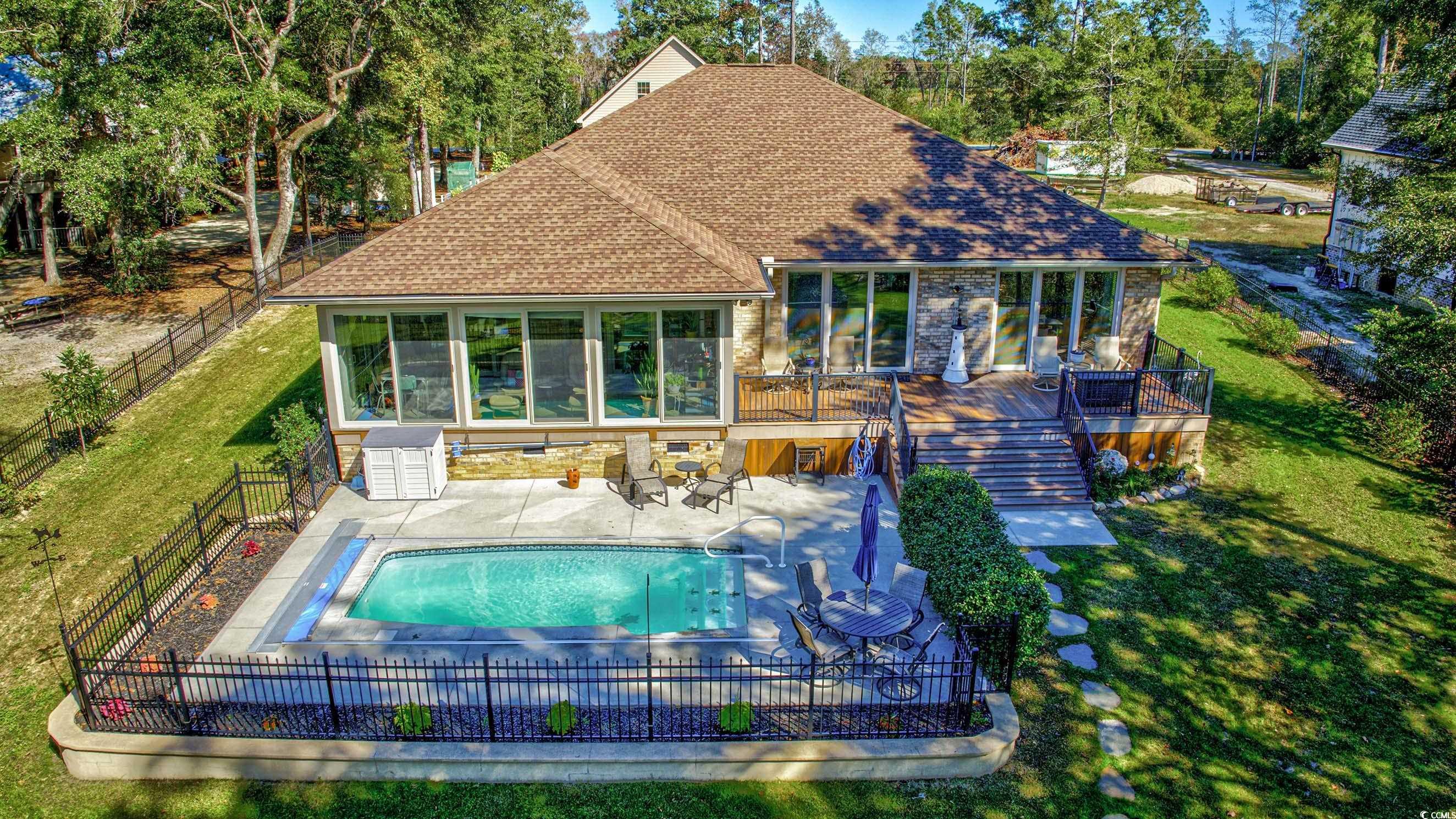 3637 Choppee Road Georgetown, SC 29440 - Photo 2 of 40 Back of house with roof with shingles, a patio area, a fenced backyard, pool, and a sunroom