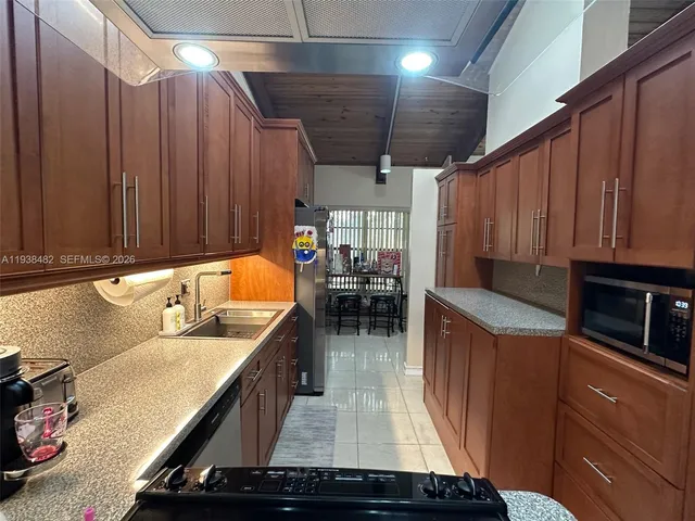 a kitchen with blue cabinets a sink a stove and a refrigerator