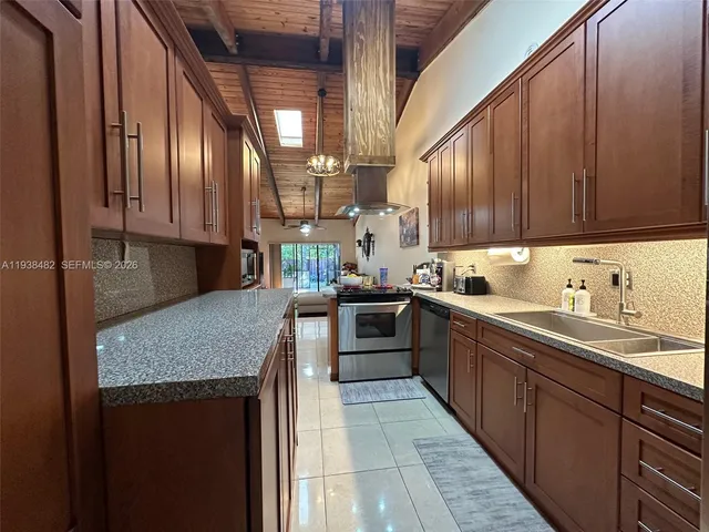 a kitchen with stainless steel appliances granite countertop a sink stove and cabinets