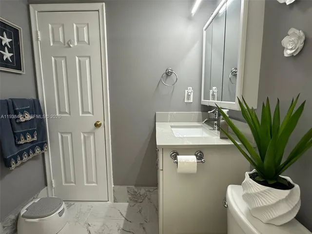 a bathroom with a toilet a sink and mirror