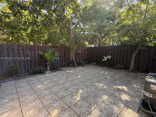 a view of backyard with potted plants and wooden fence