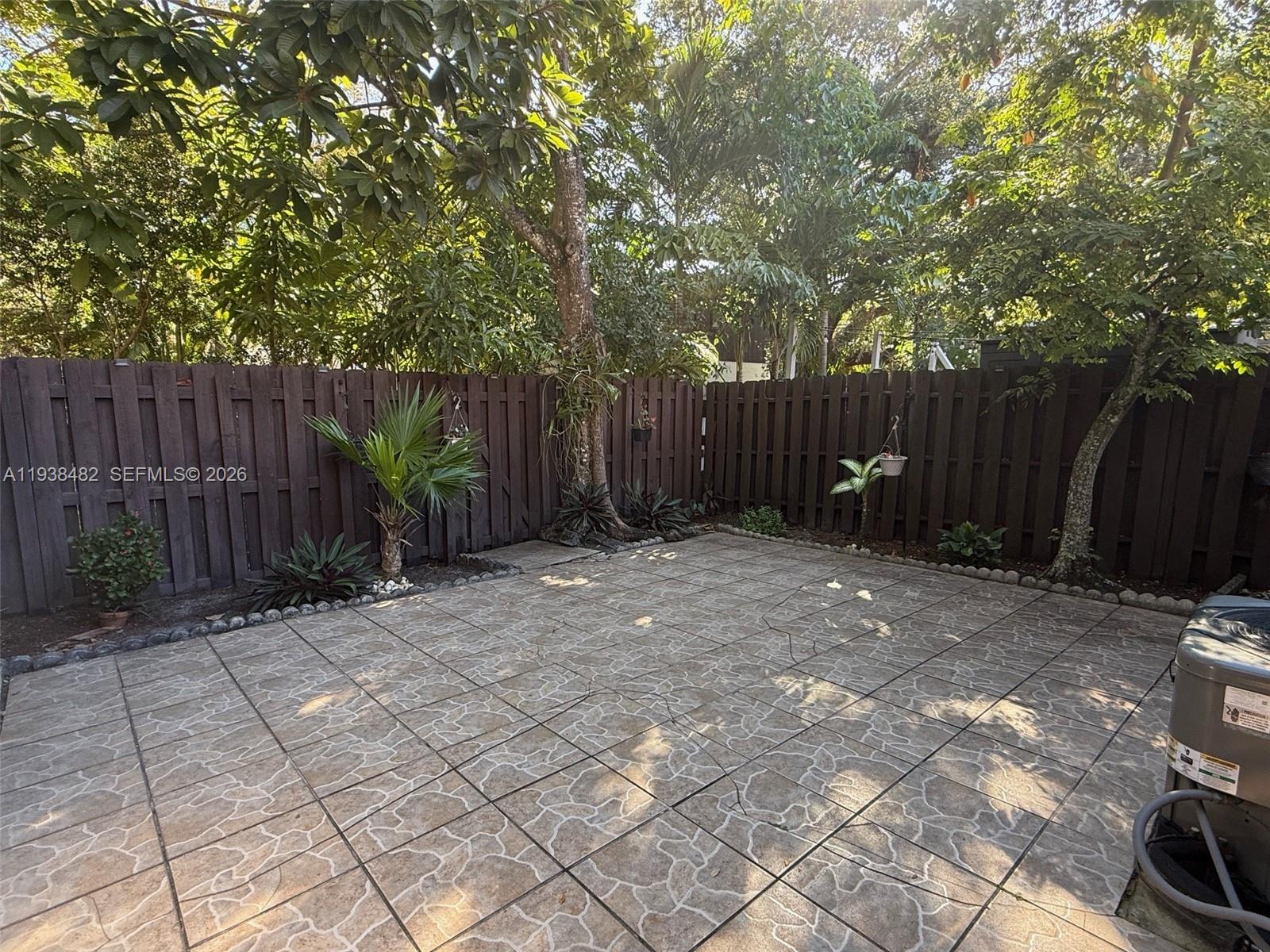 3415 Freedom Drive Hollywood, FL 33021 - Photo 3 of 49 a view of backyard with potted plants and wooden fence