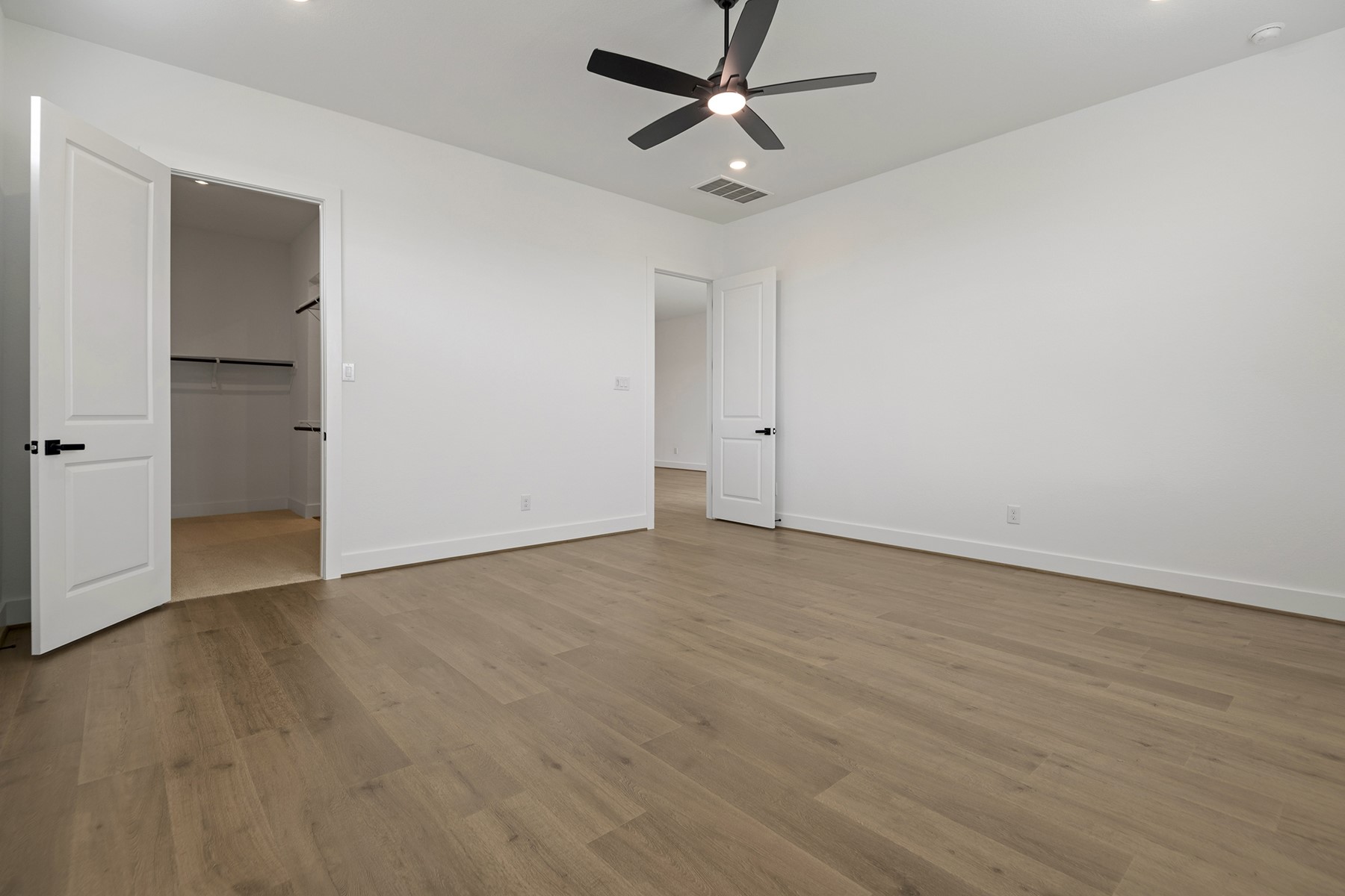 1911 Drover Lane Rosenberg, TX 77471 - Photo 17 of 22 an empty room with wooden floor ceiling fan and windows