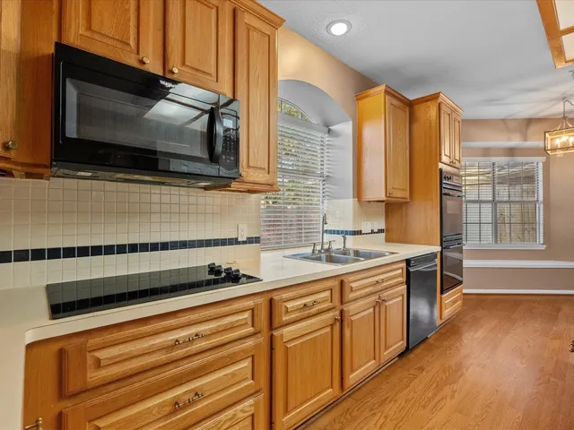 a kitchen with stainless steel appliances a sink a stove a microwave and cabinets