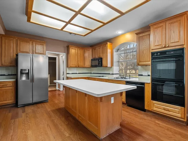 a kitchen with stainless steel appliances granite countertop a stove a refrigerator and a sink