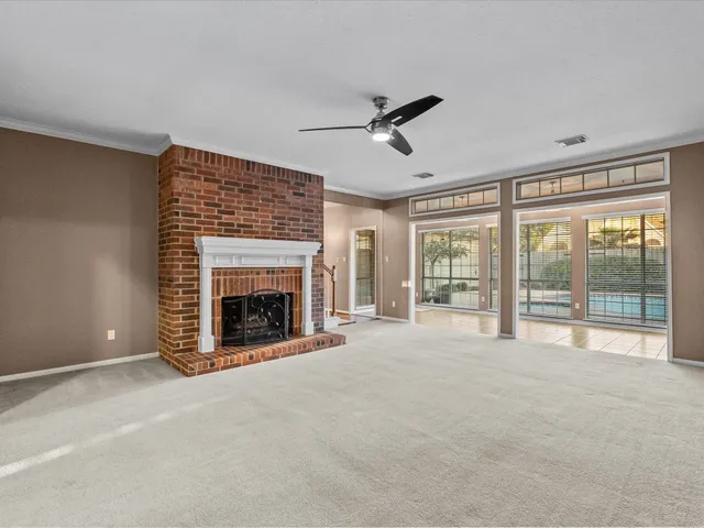 a view of an empty room with a fireplace and a window