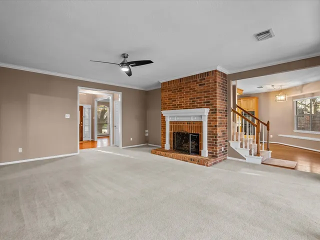 a view of an empty room with a fireplace and a window