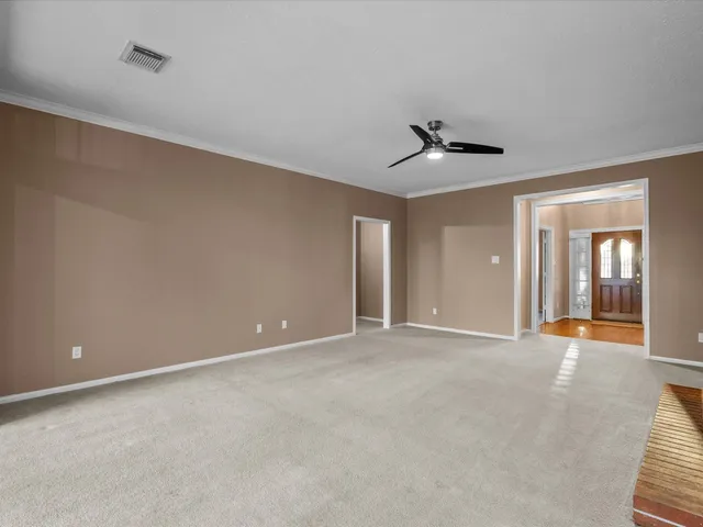 an empty room with fan and windows