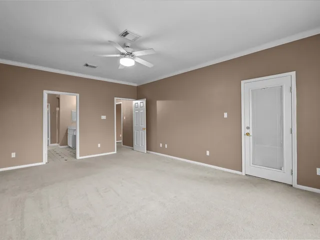 an empty room with fan and entryway