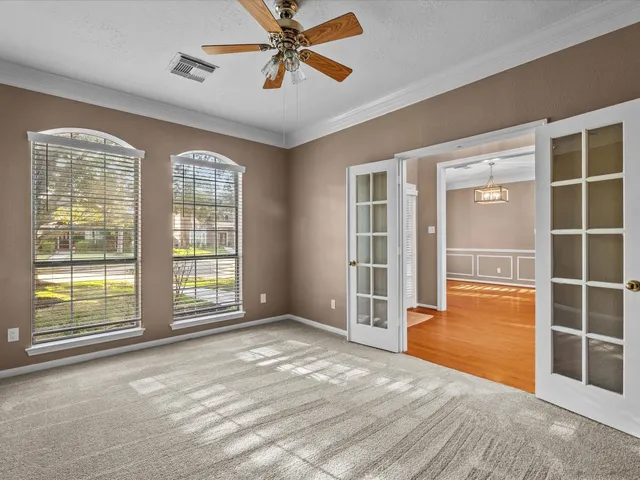 a view of an empty room with a window and wooden floor