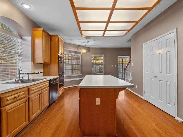 a kitchen with stainless steel appliances granite countertop a sink and wooden floors