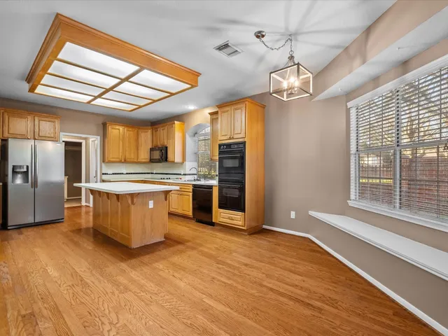 a large kitchen with stainless steel appliances granite countertop a stove and a refrigerator