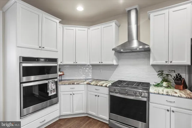 a kitchen with white cabinets and stainless steel appliances
