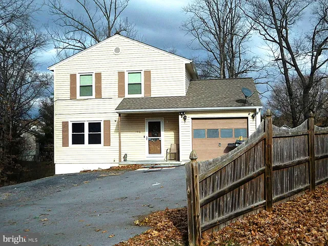 a view of a white house with large windows and a small yard