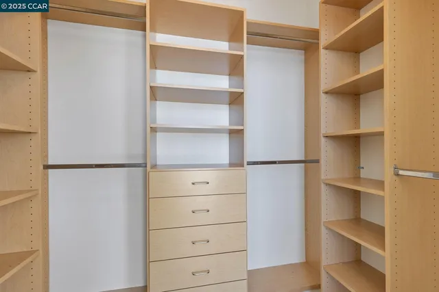 a view of walk in closet with empty racks