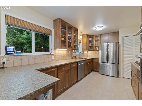 a kitchen with stainless steel appliances granite countertop a refrigerator and a sink