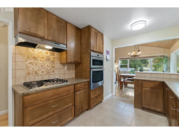 a kitchen with stainless steel appliances wooden cabinets and a stove top oven
